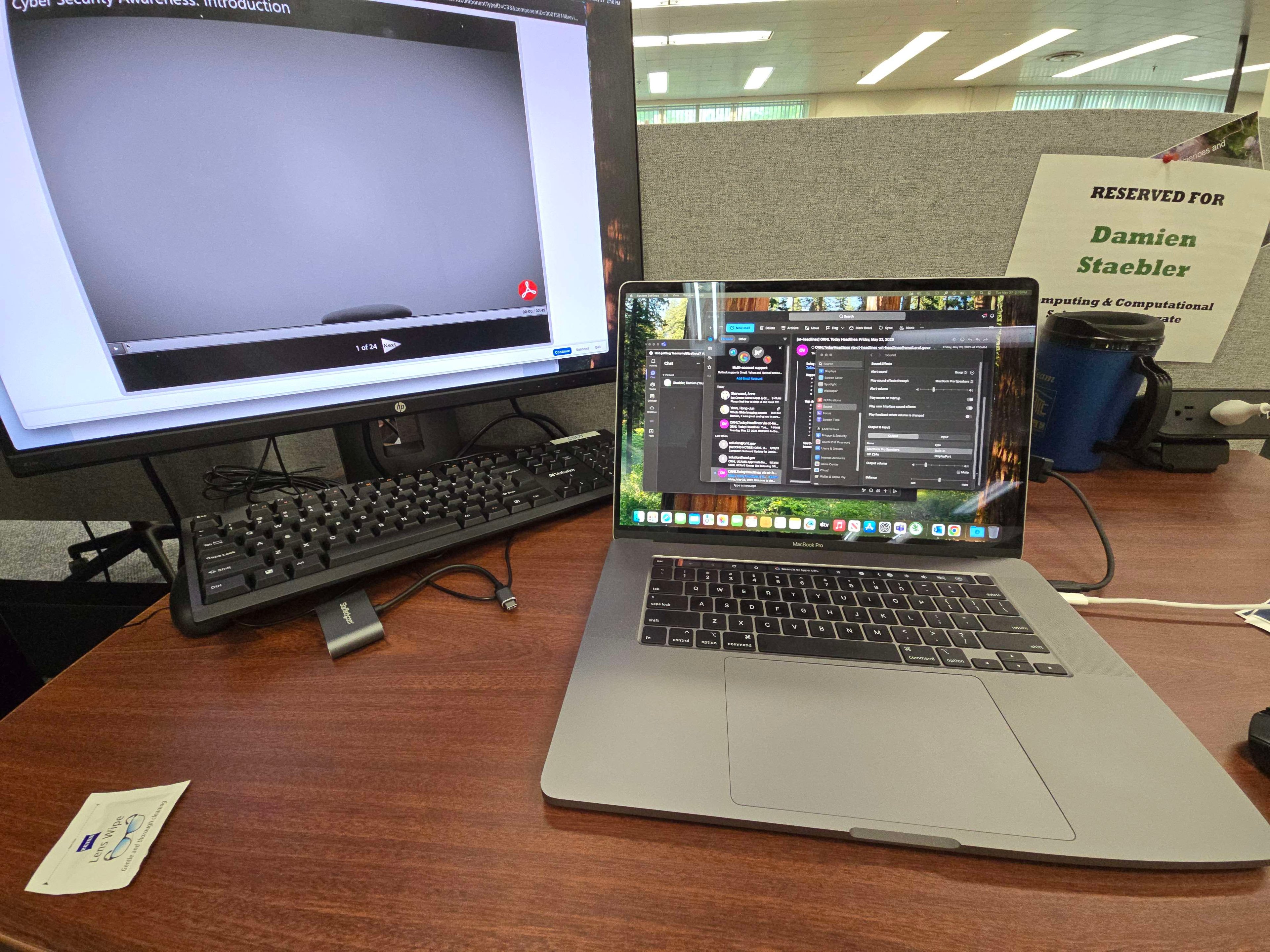 Damien Staebler’s internship workspace with a laptop, monitor, and reserved desk sign